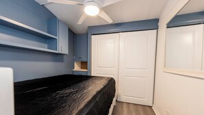 A bedroom with a bed, a ceiling fan, and a wardrobe. - Fully remodeled cozy mobile home in charming Zephyrhills with AC, WiFi (Zephyrhills)