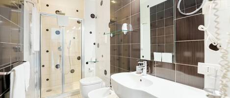 A modern bathroom with a glass shower enclosure, a white sink, and a large mirror.
