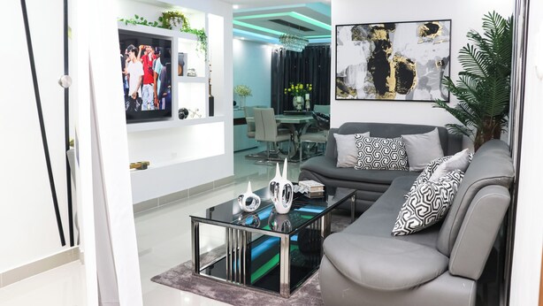 Una sala de estar moderna con un sofá, una mesa de centro y un televisor.