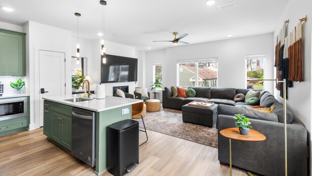 A modern kitchen with a built-in dishwasher, a large island, and a flat-screen TV.