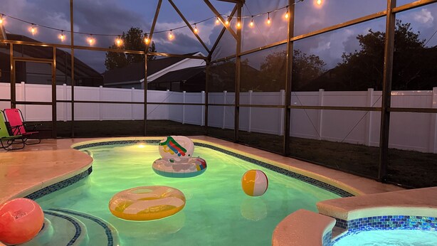 En pool med uppblåsbara leksaker och ljusslingor.