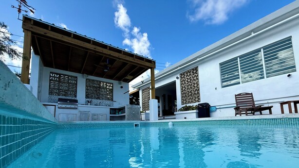 A swimming pool with a wooden deck and a covered area, a grill, and a decorative wall. - Located close to Isabel Segunda Vieques, downtown 4 bedrooms with pool. (Vieques)