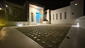 A modern building with a geometric patterned patio, a central staircase, and a well-lit entrance. - Located close to Isabel Segunda Vieques, downtown 4 bedrooms with pool. (Vieques)