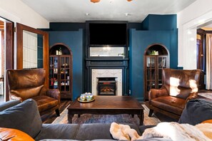 Una Smart TV, una chimenea, libros, una biblioteca de música