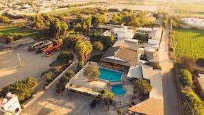An aerial view of a residential area with a swimming pool, a bus station, and a vineyard. - Hotel Fundo San Rafael  (Nazca)