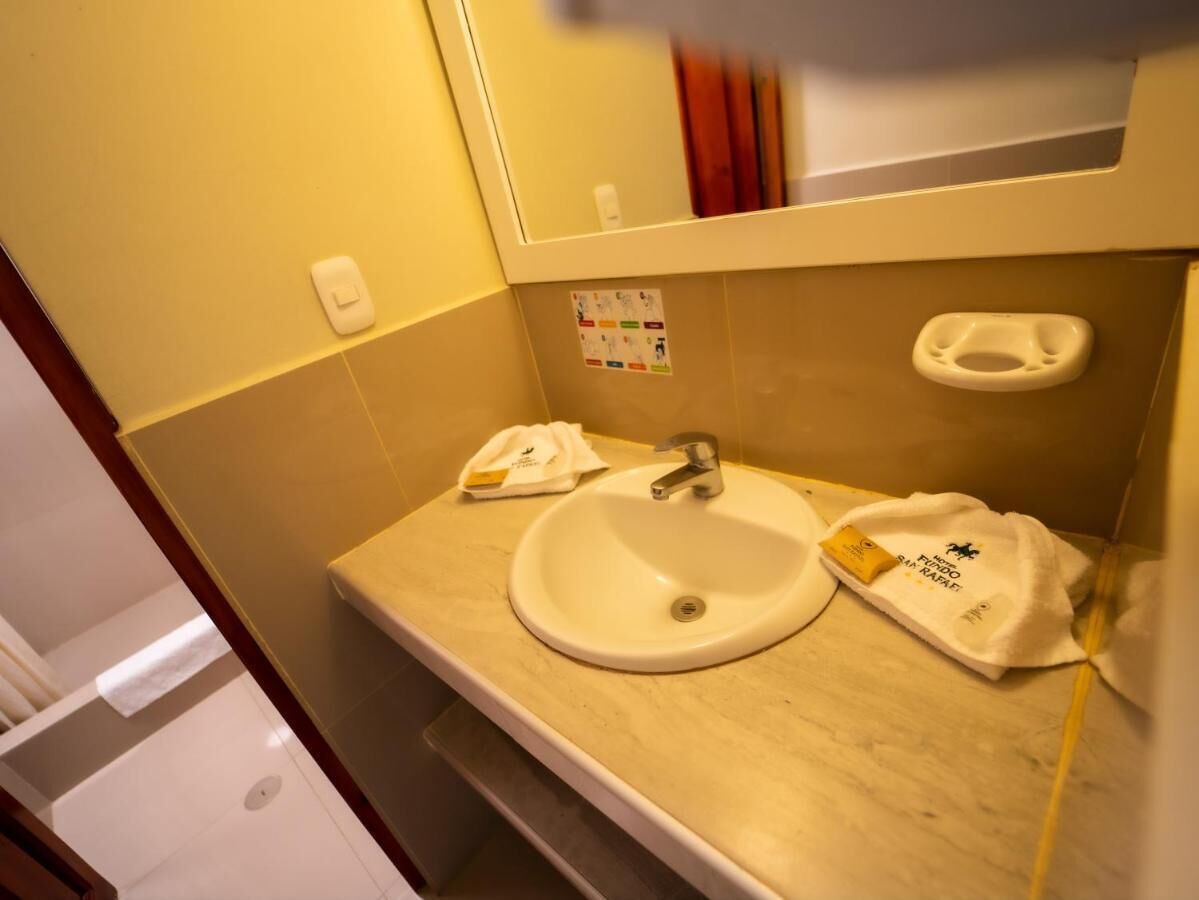 Een badkamer met een wastafel, spiegel en handdoekhouder.