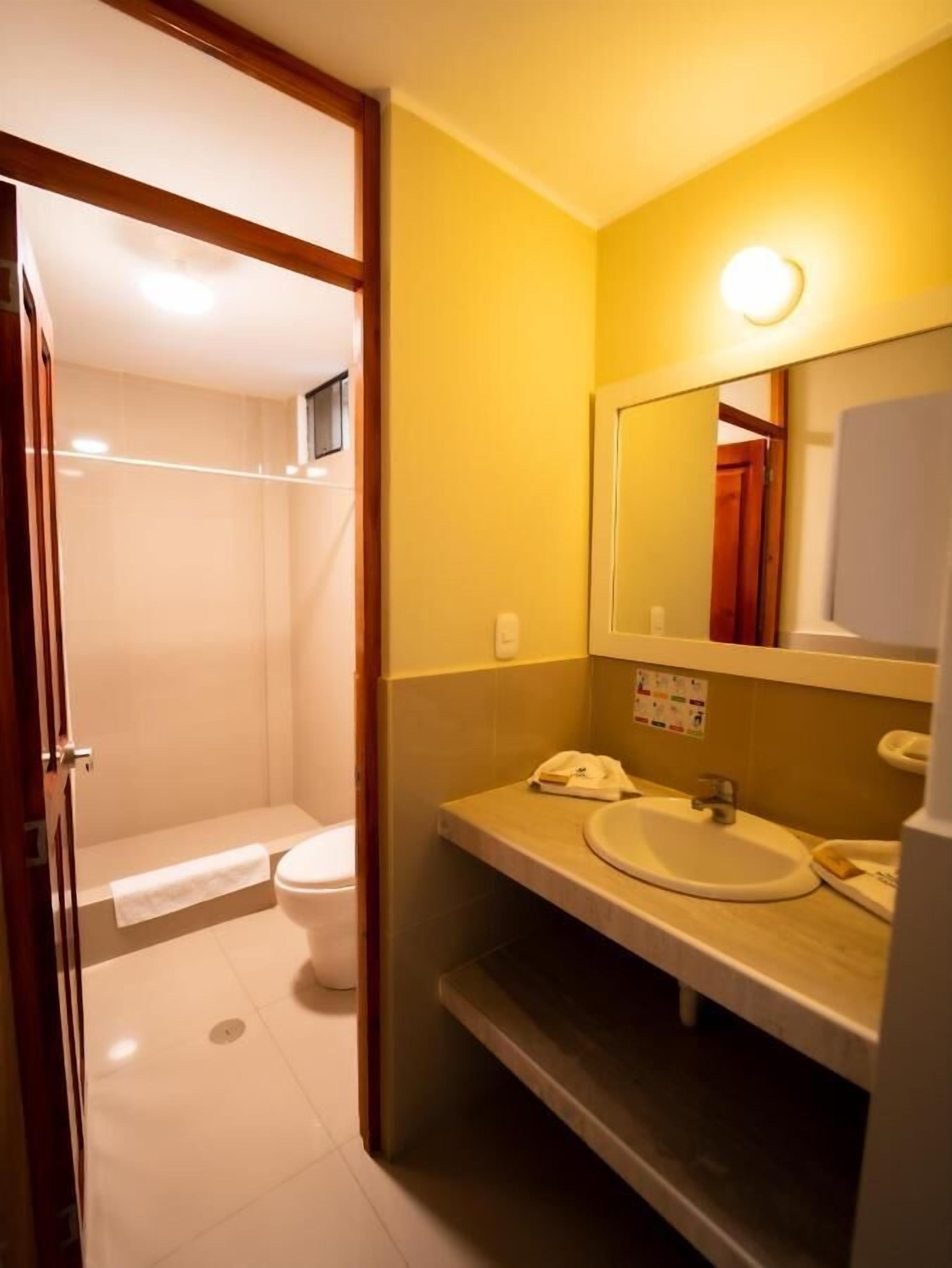 Un baño con inodoro, lavamanos y ducha.