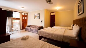 A hotel room with two beds, a sofa, a desk, and a chair. - Hotel Fundo San Rafael  (Nazca)