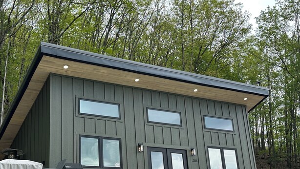 Un bâtiment moderne à deux étages, doté d’un toit plat, de grandes fenêtres et de fondations en béton.
