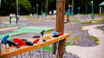 Une balançoire en bois avec des sièges colorés, installée dans un parc.