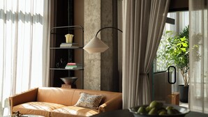 A modern living room with a leather sofa, a round coffee table, a bookshelf, and a potted plant. - Mint House Nashville Marathon Village by Kasa (Nashville)