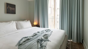 A neatly made bed with white linens, a grey blanket, and a wall-mounted artwork of a horse. - Mint House Nashville Marathon Village by Kasa (Nashville)