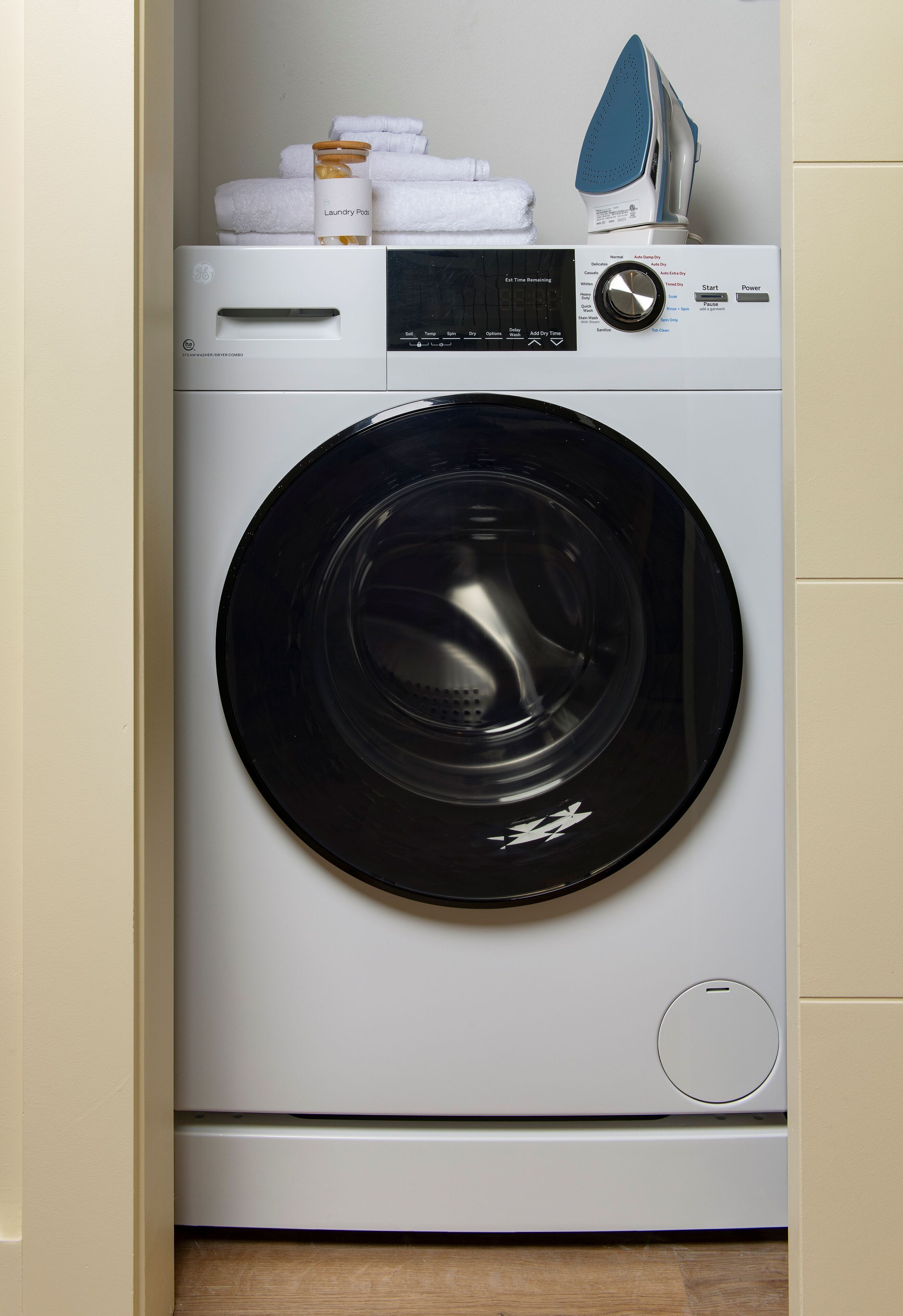 A front view of a modern, compact washing machine with a control panel and a built-in dryer.