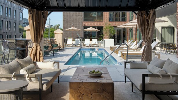 A rooftop pool area with lounge chairs, a pool table, and a view of the cityscape. - Mint House Nashville Marathon Village by Kasa (Nashville)