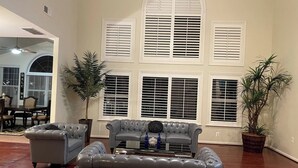 A spacious living room with a grey sofa set, a coffee table, and a dining area with a table and chairs. - Lex Holmes Luxury House (Fort Washington)