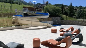 An outdoor seating area with modern chairs and a slide.