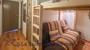 A room with a bunk bed, a door, and a small window.