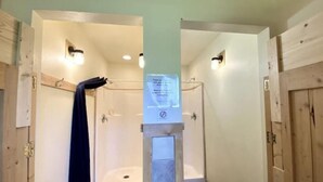 A bathroom with wooden walls, a towel hanging on a rack, and a sign on the wall. - West Yellowstone Station At Mountain River Ranch (Ririe)