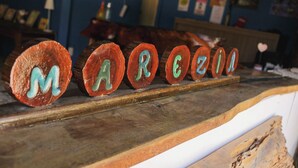 Bloques de madera con letras que deletrean “MARCEZIO” sobre una estantería.