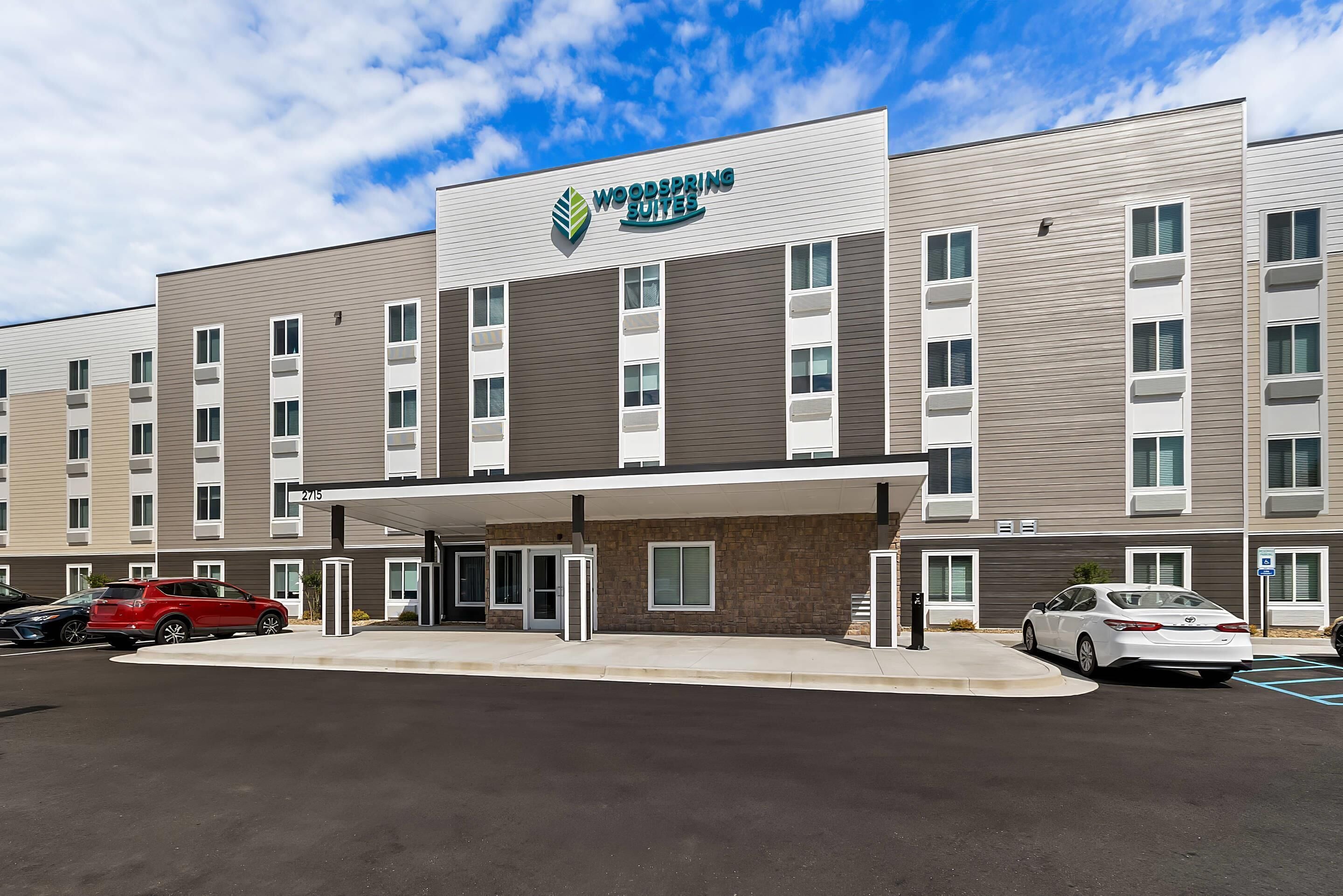 A hotel with a modern design, featuring a flat roof and a covered entrance.