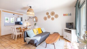 Ein modernes Wohnzimmer mit Sofa, Esstisch und TV-Schrank.