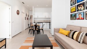 Una sala moderna con un sofá, una mesa de centro y un comedor con sillas y una mesa.