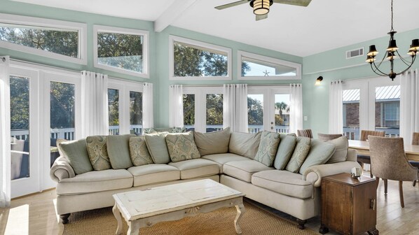 A large L-shaped sectional sofa with multiple cushions, a rustic coffee table, and a wooden cabinet. - Your Ideal Beach Getaway With Private Pool, Game Room and Close to Beach! (Santa Rosa Beach)