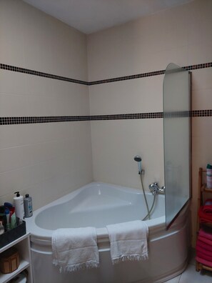 A bathroom with a freestanding bathtub, a glass shower enclosure, and a mirror. - Charming house with a pool and garden, 10 minutes from the ocean (Biscarrosse)