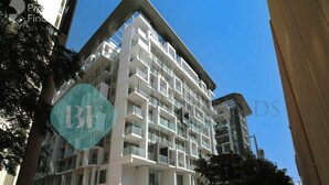 A modern multi-story hotel with balconies and a clear blue sky. - Bloomfields Executive 1BR Oasis Masdar (Abu Dhabi)