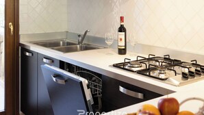 Une cuisine moderne équipée d’un lave-vaisselle, d’un évier, d’une cuisinière et d’une bouteille de vin.