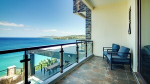 A balcony with a glass railing overlooking a sea view. - Luxury Oceanfront Villa~ Fully Staffed~Pool~Jacuzzi~Movie Theatre (tower isle)