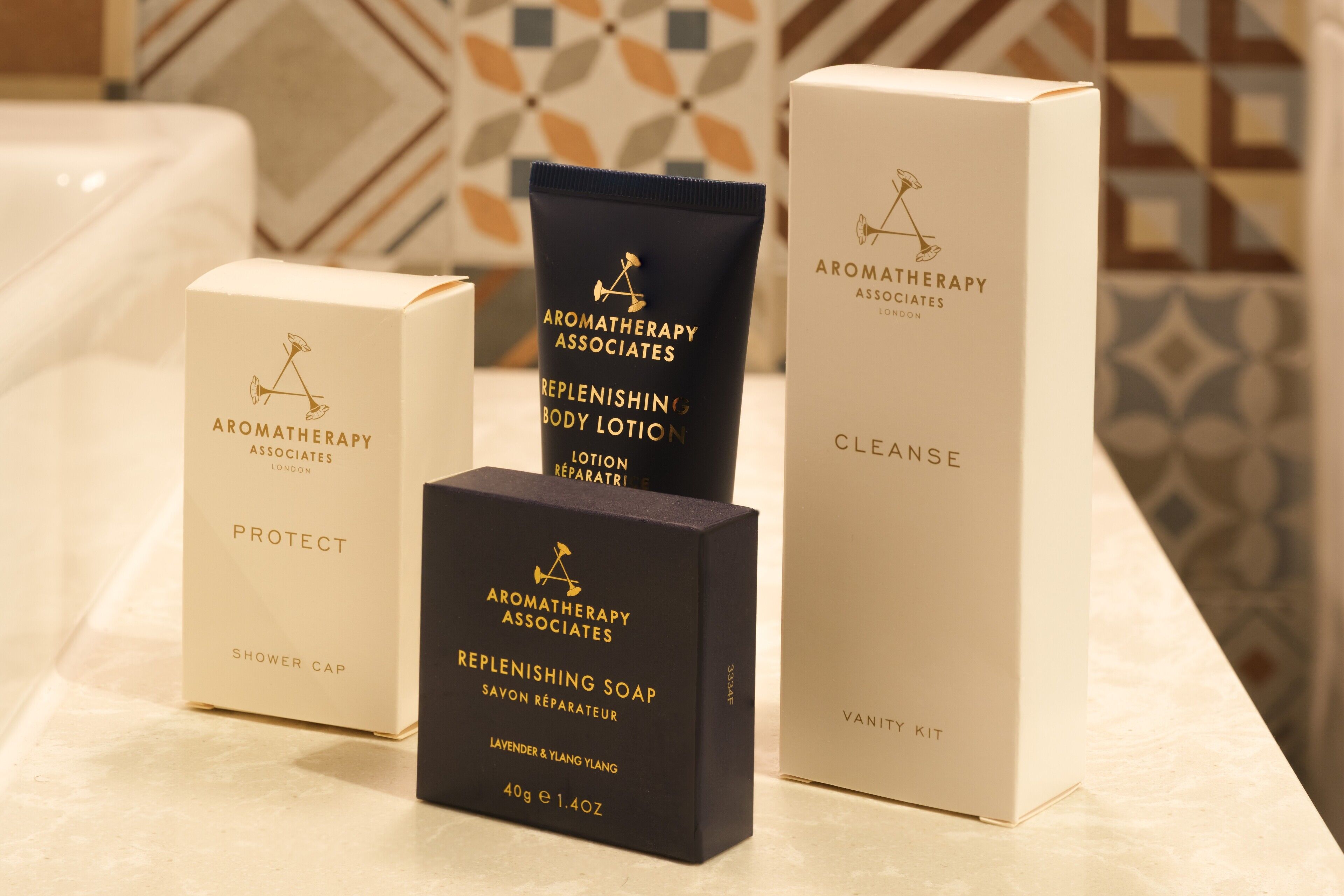 A bathroom with a shower cap, replenishing body lotion, replenishing soap, and a vanity kit.