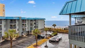 Un hotel de varios pisos con balcones que dan a una playa.