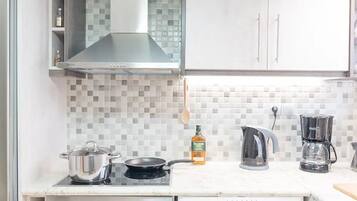 A compact kitchen with a built-in oven, microwave, and a front-loading washing machine.