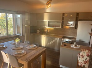 Enjoy meals in the kitchen with a large window offering a view of the surrounding trees.