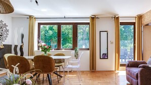 Una sala moderna con comedor, ventanas amplias y vista a espacios verdes.
