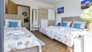A hotel room with two beds, a chair, a desk, and a large window. - Apartments Villa Mavi - Two Bedroom Apartment First Floor (Karlovac)