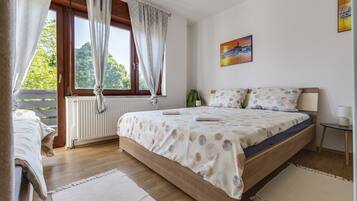 Een slaapkamer met een houten bed, een raam met gordijnen, een radiator en een schilderij aan de muur.