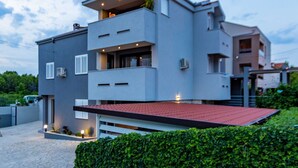 A modern two-story house with a flat roof, large windows, and a balcony. - Three Bedroom Apartment with Private Pool (Zadar)