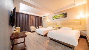 Quarto de hotel com duas camas, uma escrivaninha, uma cadeira, uma televisão e um quadro na parede.