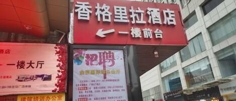 A hotel sign with a red banner and a QR code.