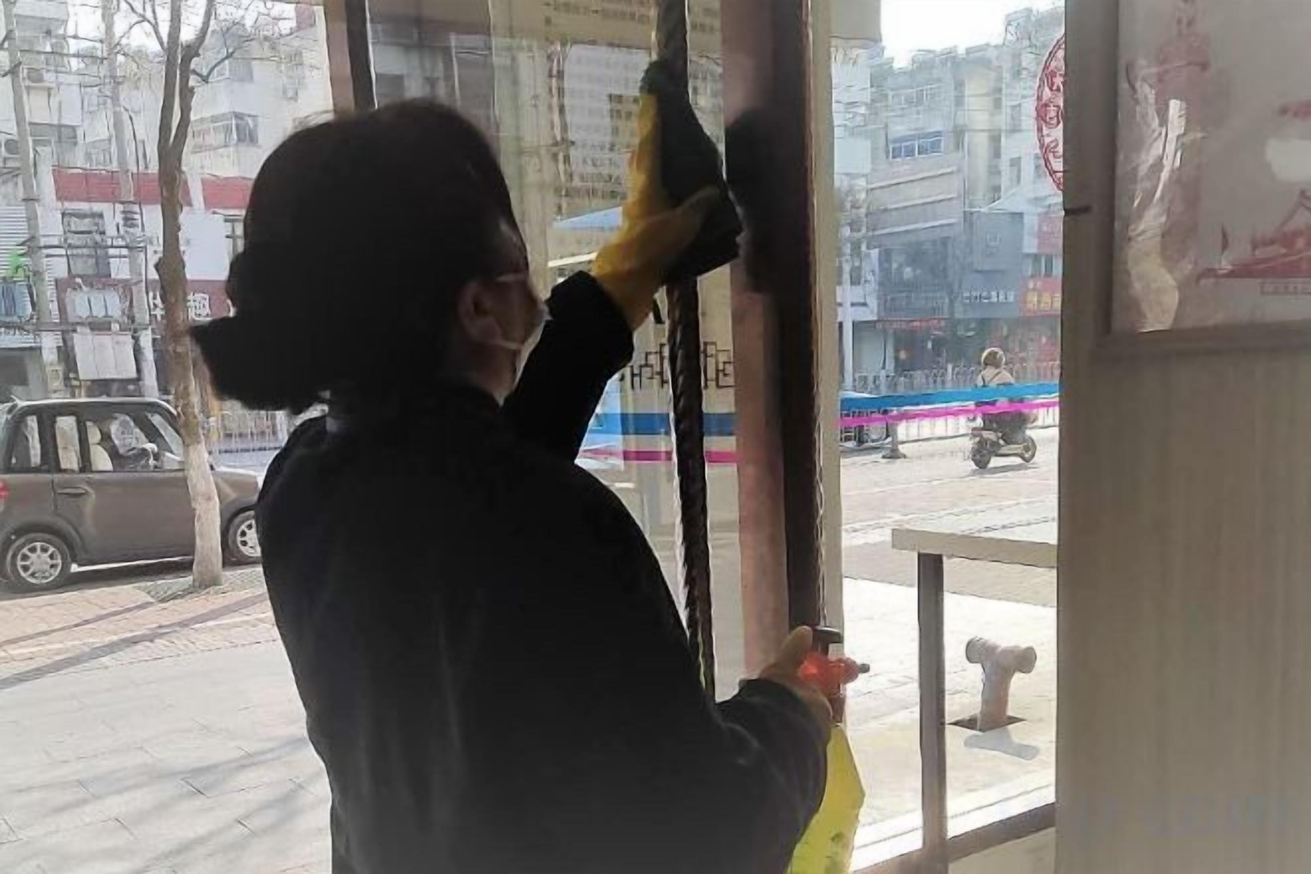 A person cleaning a window with a squeegee.