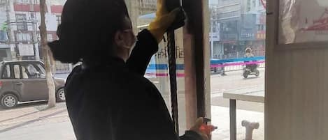 A person cleaning a window with a squeegee.