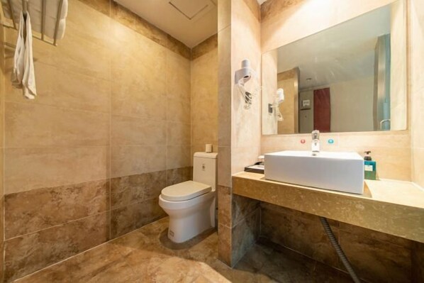 Un baño con inodoro, lavamanos y espejo.