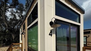 Een modern, gelijkvloers gebouw met grote ramen en een terras.