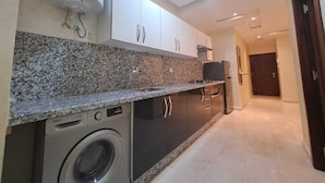 A modern kitchen with granite countertops, built-in appliances, and dark cabinetry.