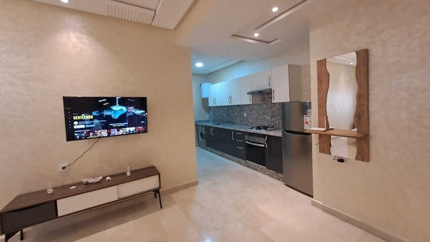 A modern kitchen with granite countertops, a built-in oven, and a stainless steel refrigerator.