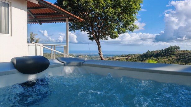 Un jacuzzi con vista al océano y las colinas.