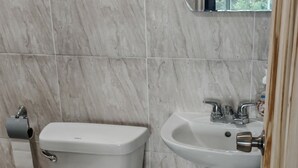 Un baño con inodoro, bidé y lavamanos.