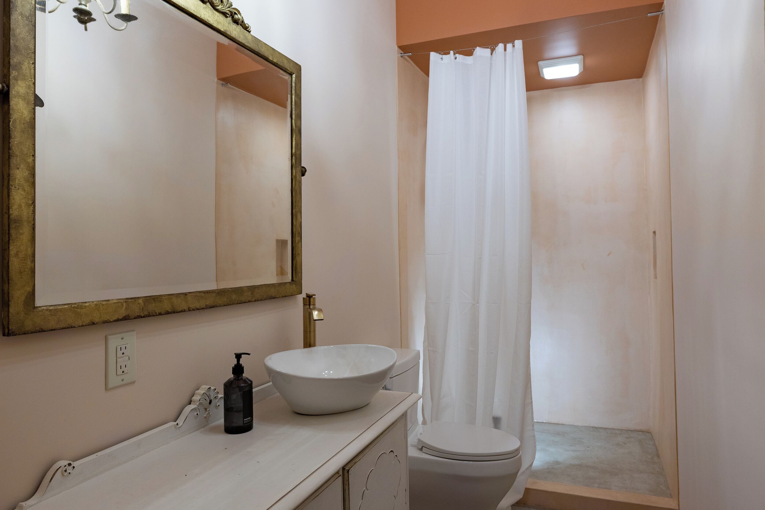 A bathroom with a white sink, a large mirror, and a shower curtain.